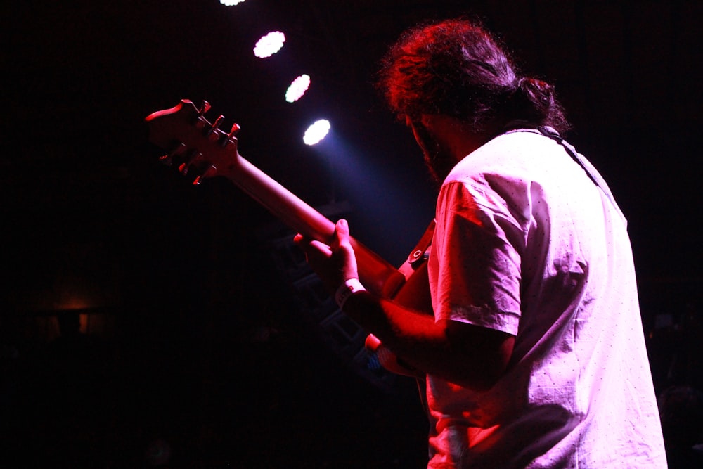 a man playing a guitar on stage at a concert