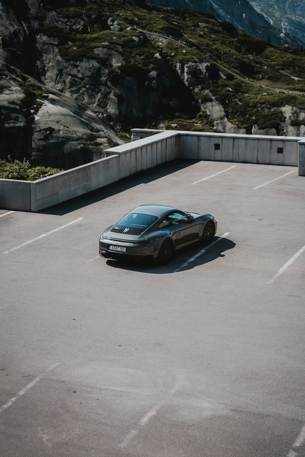 a car parked in a parking lot with mountains in the background