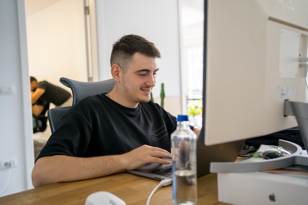 a man sitting at a desk working on a computer