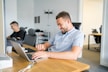 a man sitting in front of a laptop computer