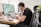 A man working efficiently at a desk with multiple screens.