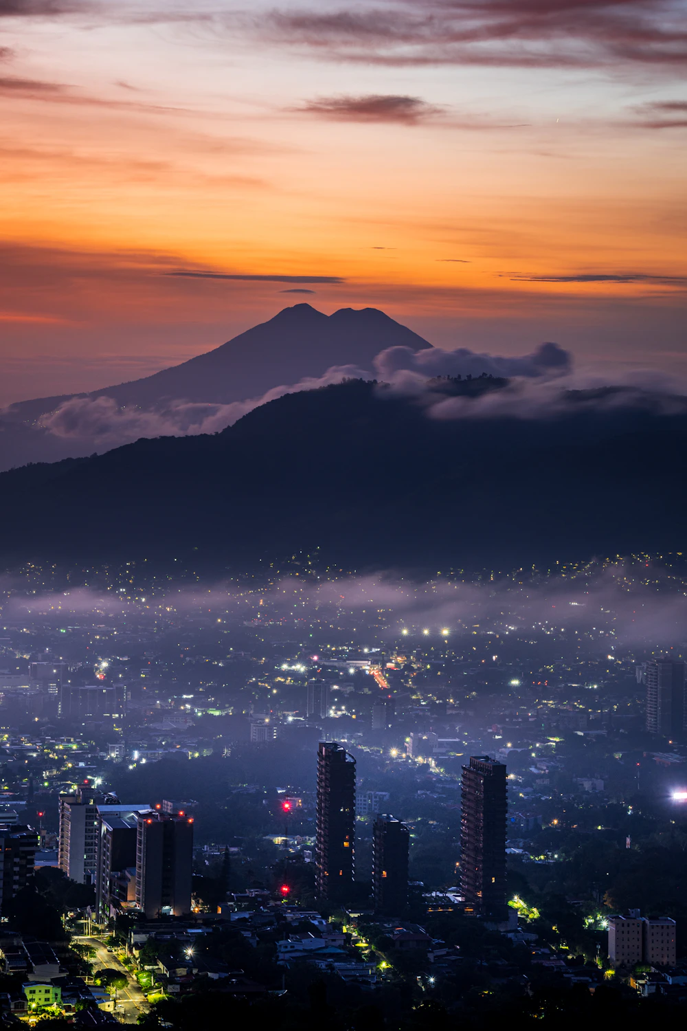 San Salvador at dusk with its volcano rising behind the city