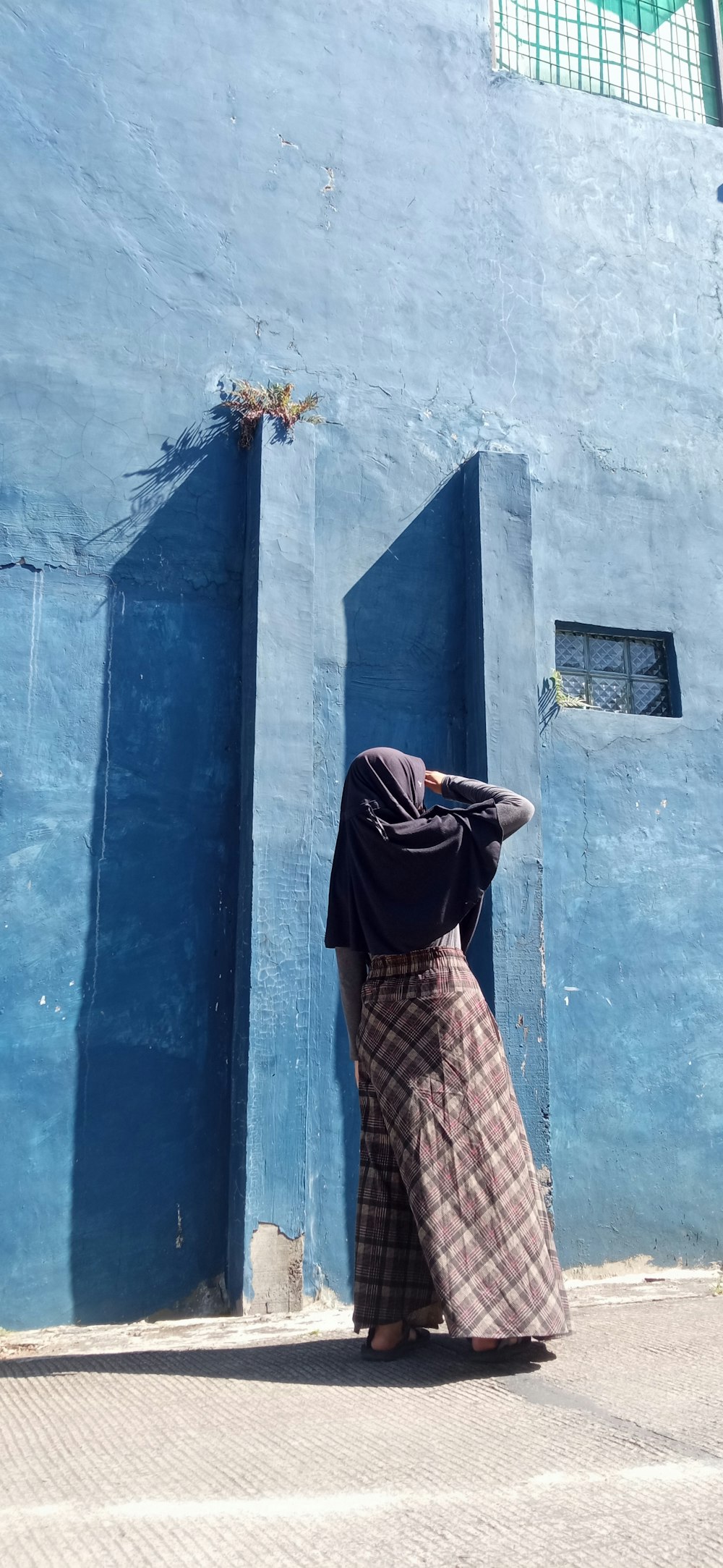 a woman standing in front of a blue building