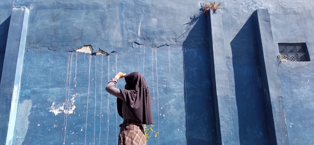 a man standing in front of a blue wall