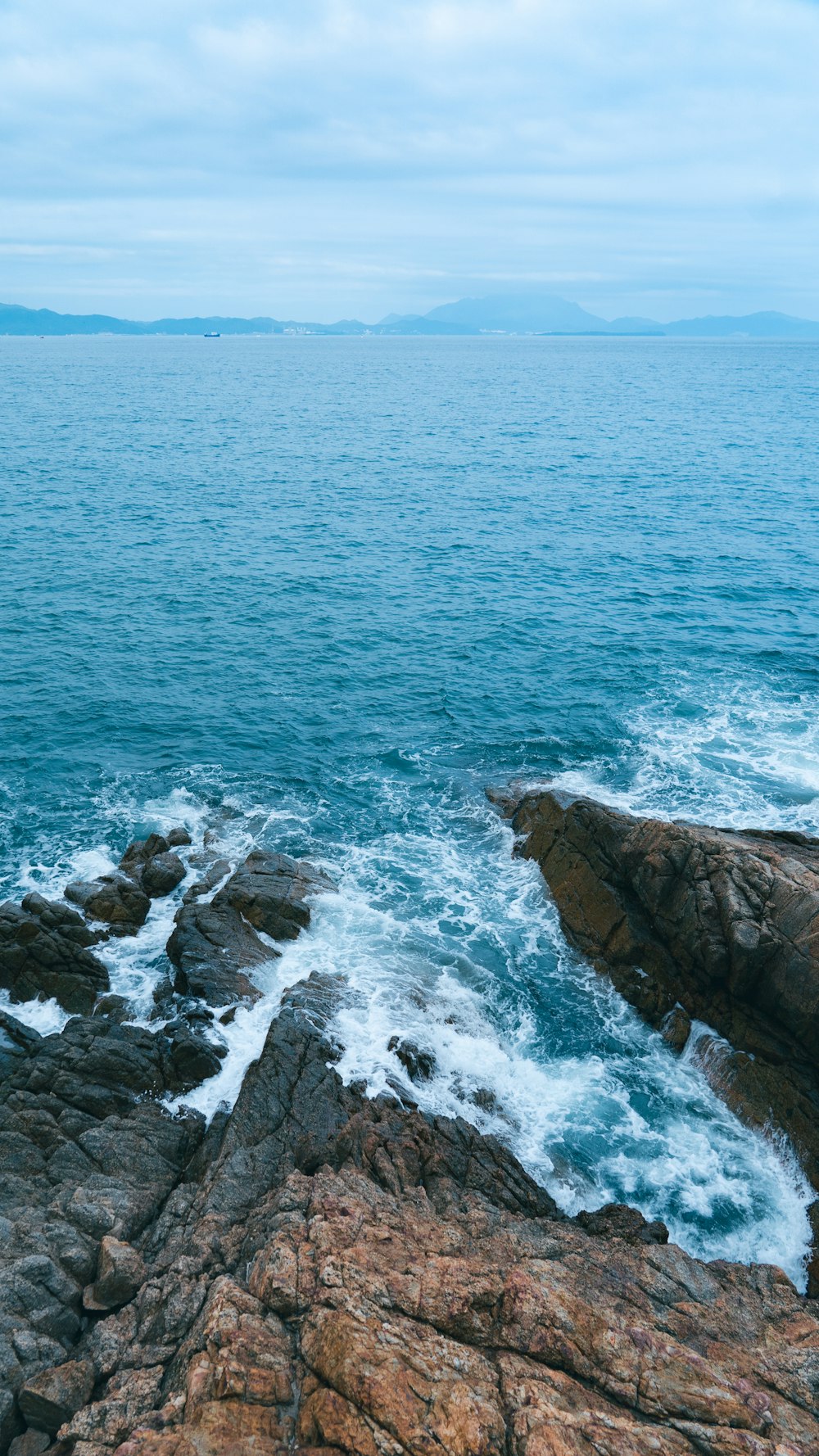 a rocky shore with waves crashing against the rocks