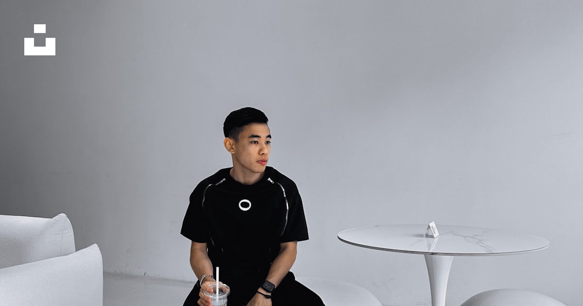 A man sitting on top of a white ball in a room photo – Free Swol cafe ...