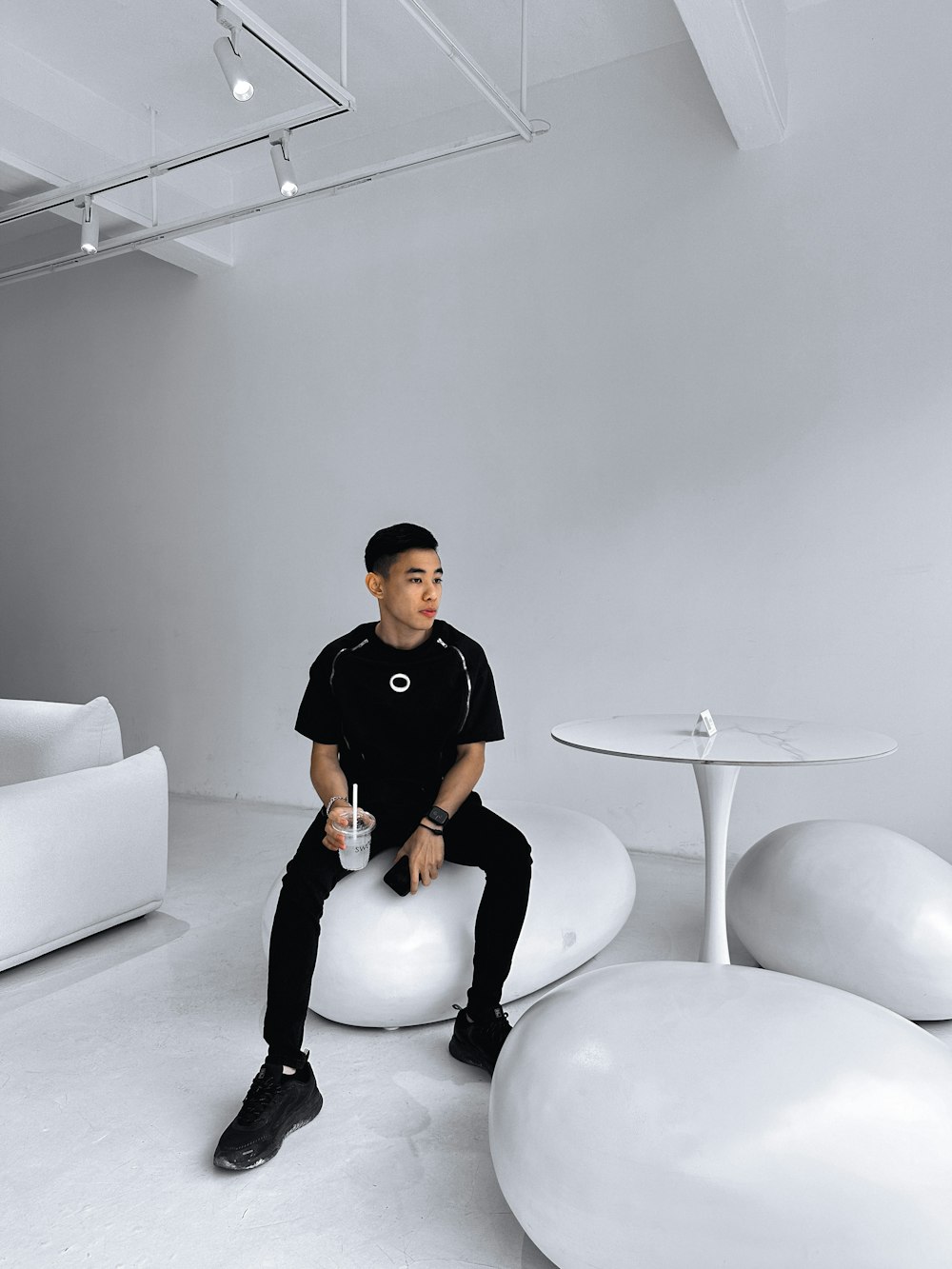 a man sitting on top of a white ball in a room