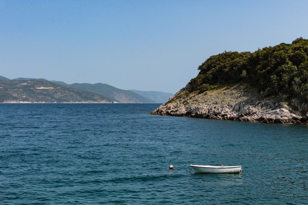 a small boat floating on top of a body of water