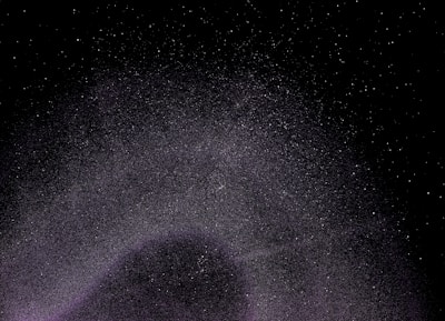 A vast expanse of the night sky filled with countless stars scattered across a dark backdrop, creating a sense of depth and infinity.