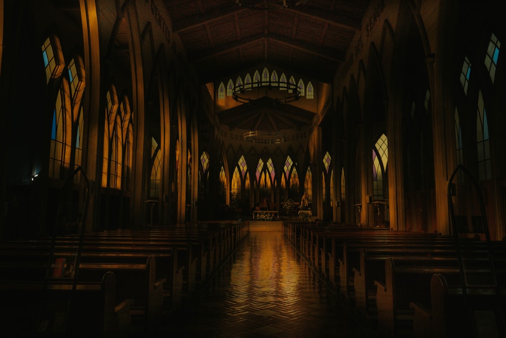 a dimly lit church with stained glass windows