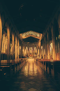 A warm, sunlit church interior with parishioners gathered around the altar during a sacrament ceremony.