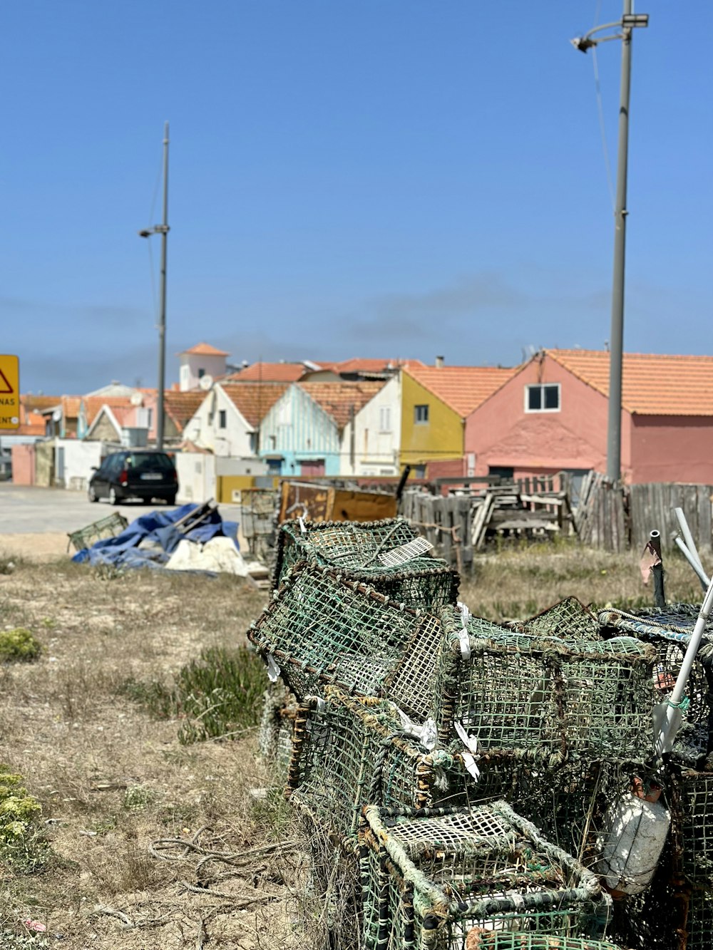 a pile of lobster traps sitting on top of a dry grass field