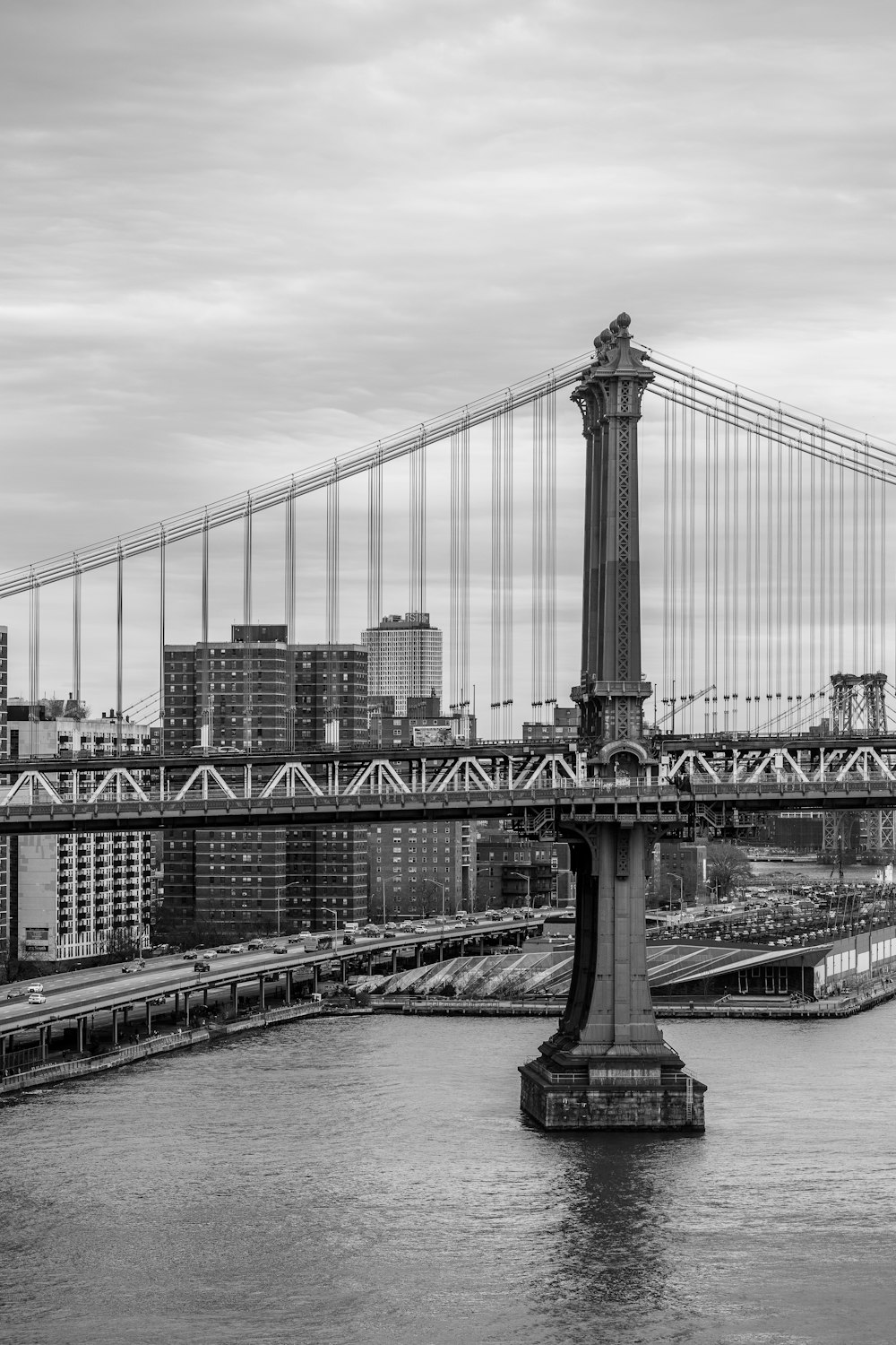 a black and white photo of a bridge over a river