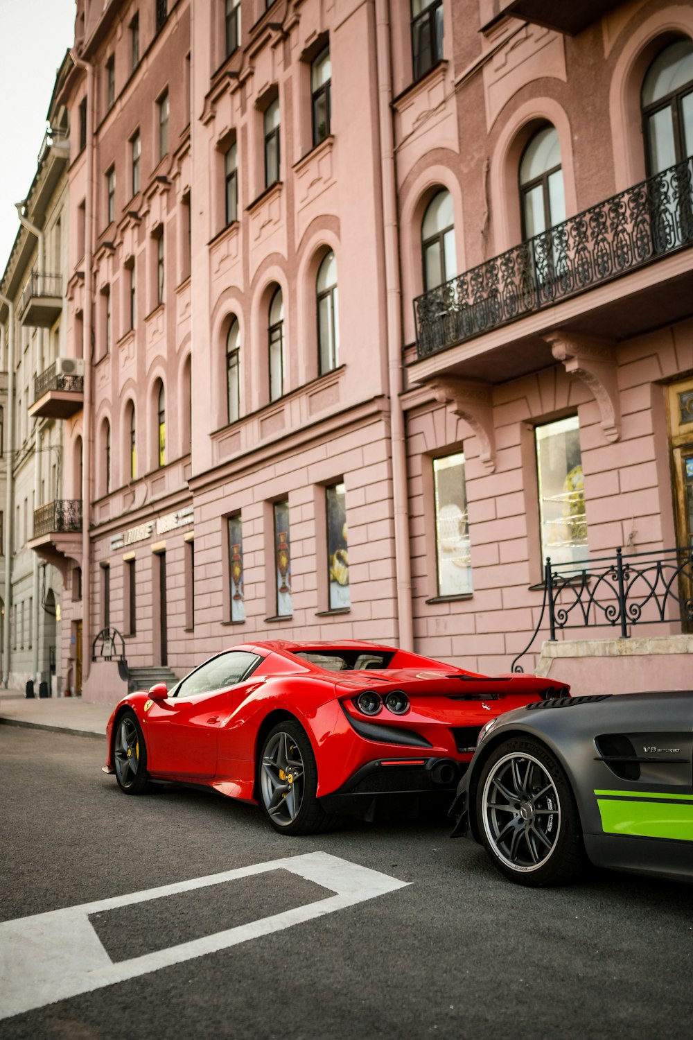 a red sports car parked next to a black sports car