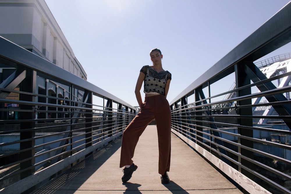 a woman is standing on a bridge posing for a picture