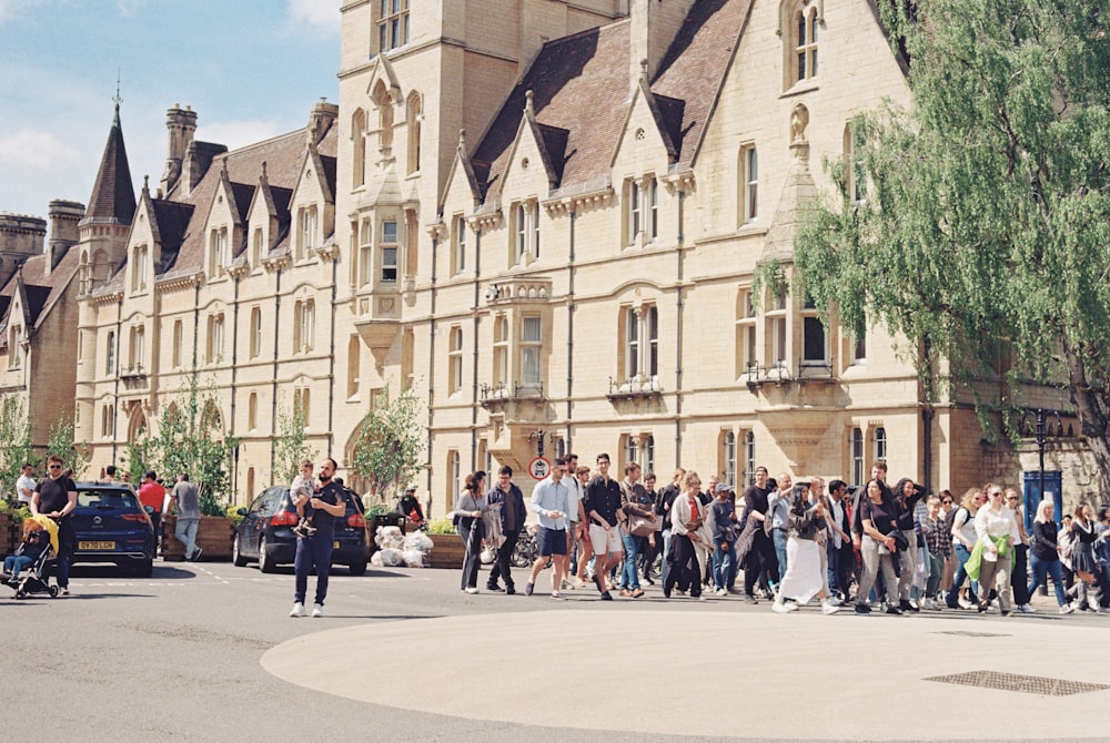 a large group of people walking in front of a building