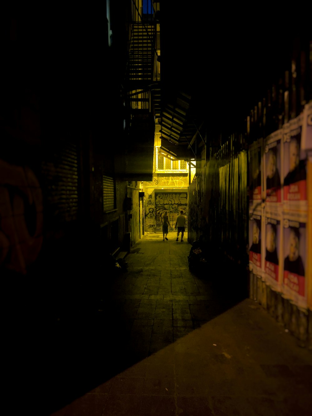 a person walking down a dark alley way