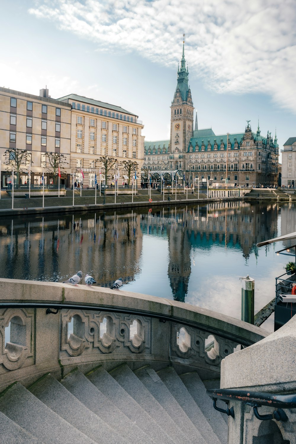 a large building with a clock tower next to a body of water