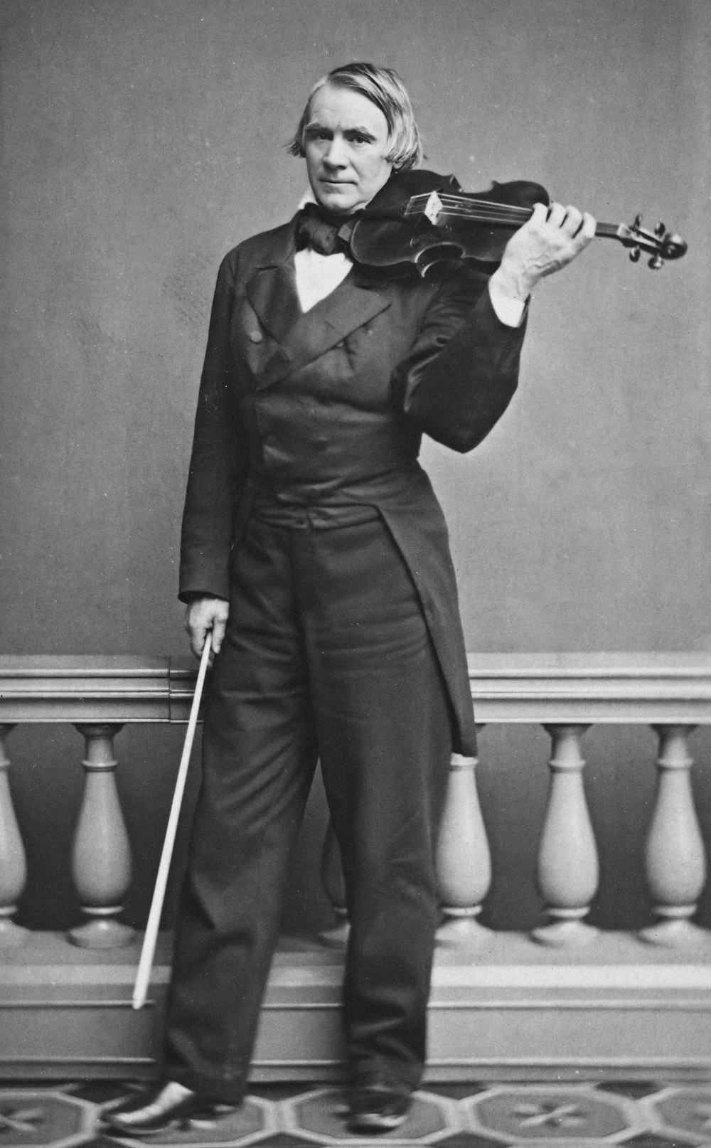 an old photo of a man holding a violin