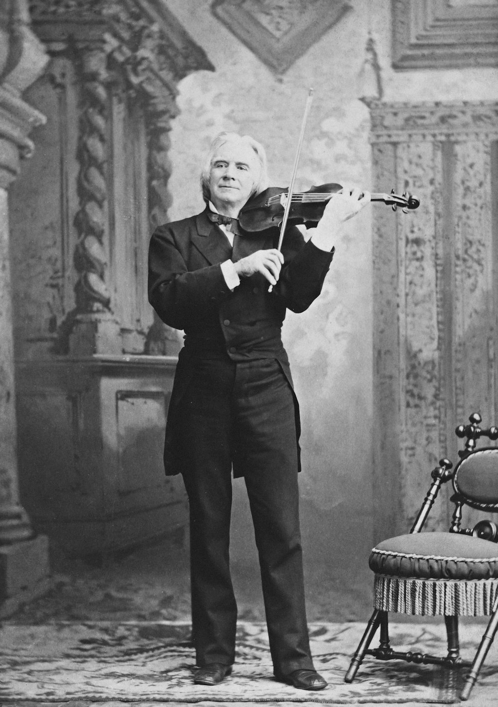 an old photo of a man holding a violin