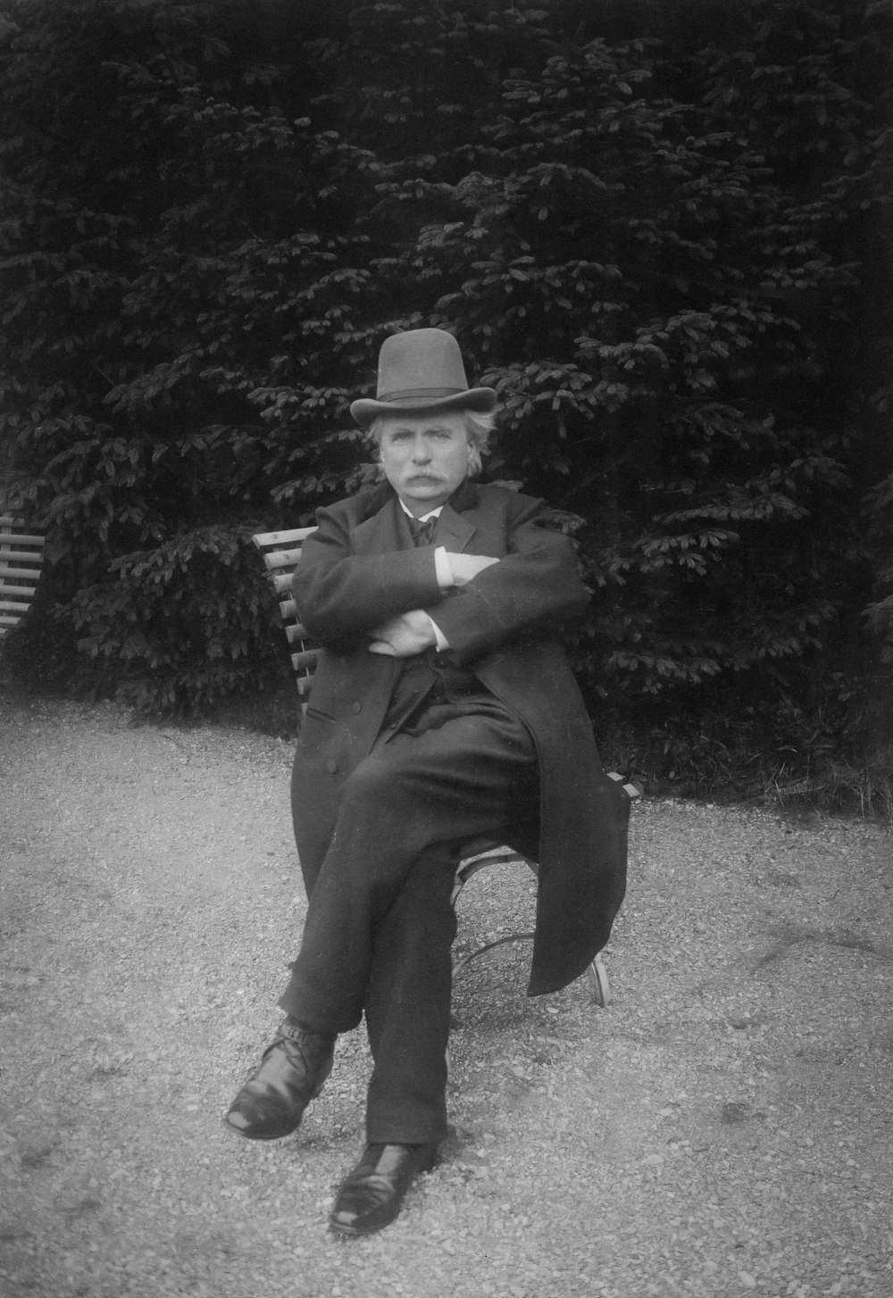 a black and white photo of a man sitting on a bench