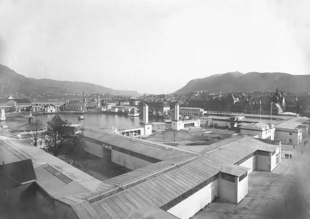 a black and white photo of a city with mountains in the background