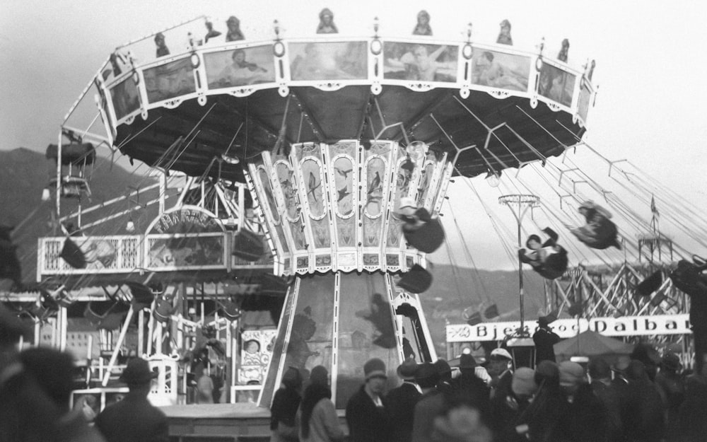 a crowd of people standing around a carnival ride