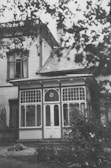 Black and white photo of the house facade from the 1920s showing original architecture.