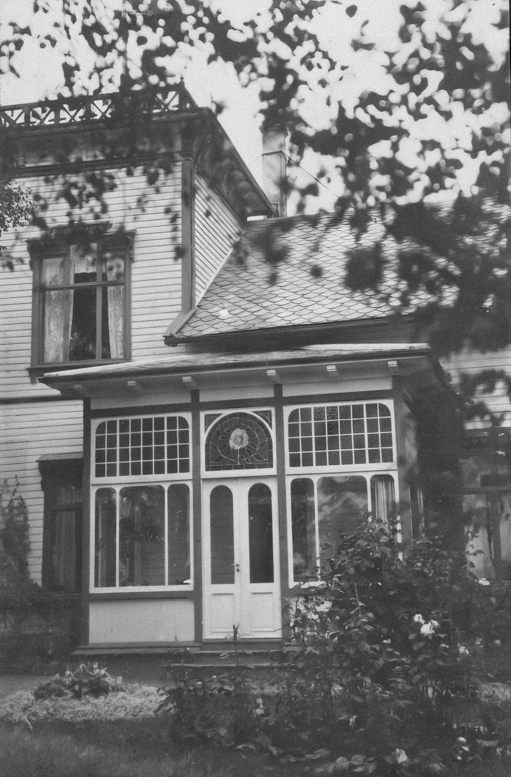 an old photo of a house with a lot of windows