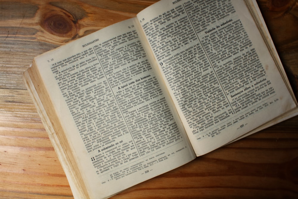 an open book sitting on top of a wooden table