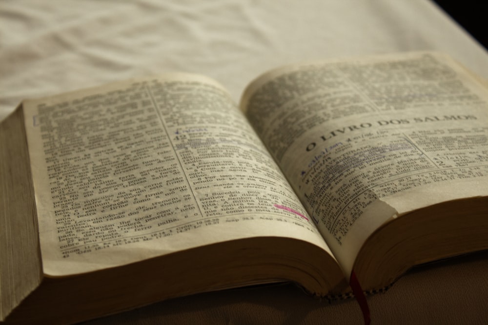 an open book sitting on top of a bed