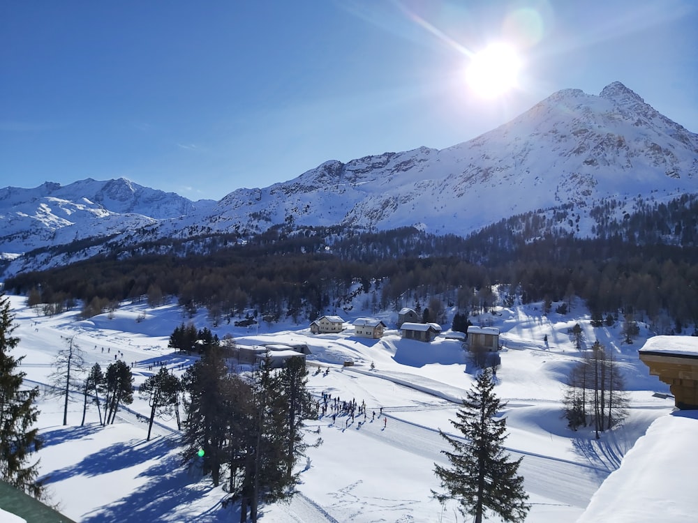 the sun is shining over a snowy mountain