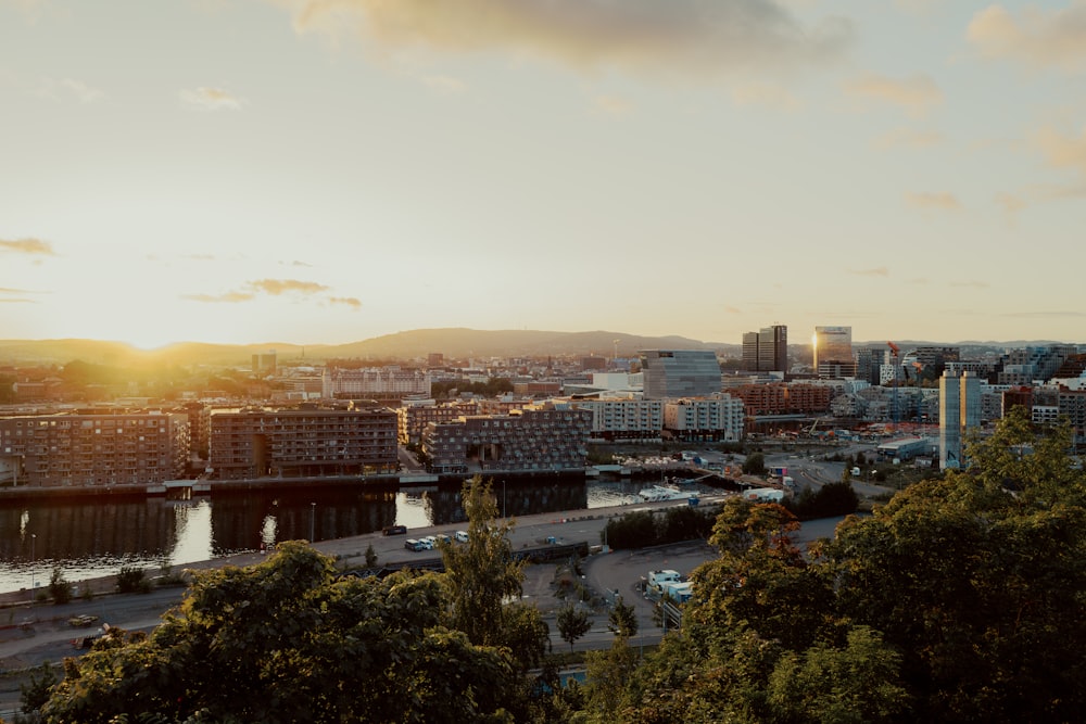 the sun is setting over a city with a river running through it