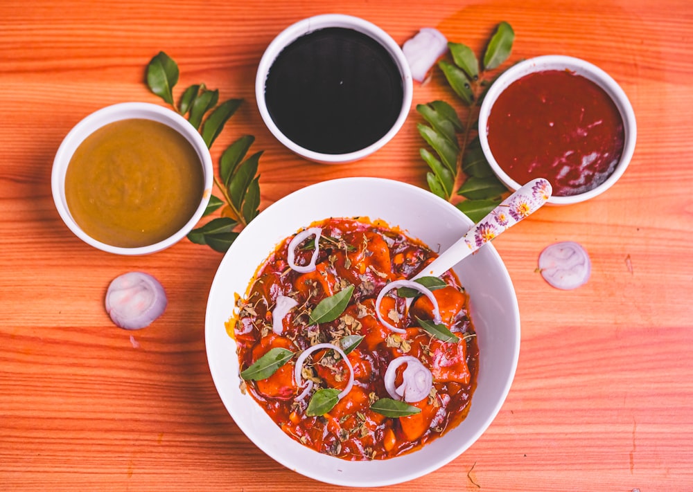 a bowl of soup and two cups of soup on a table