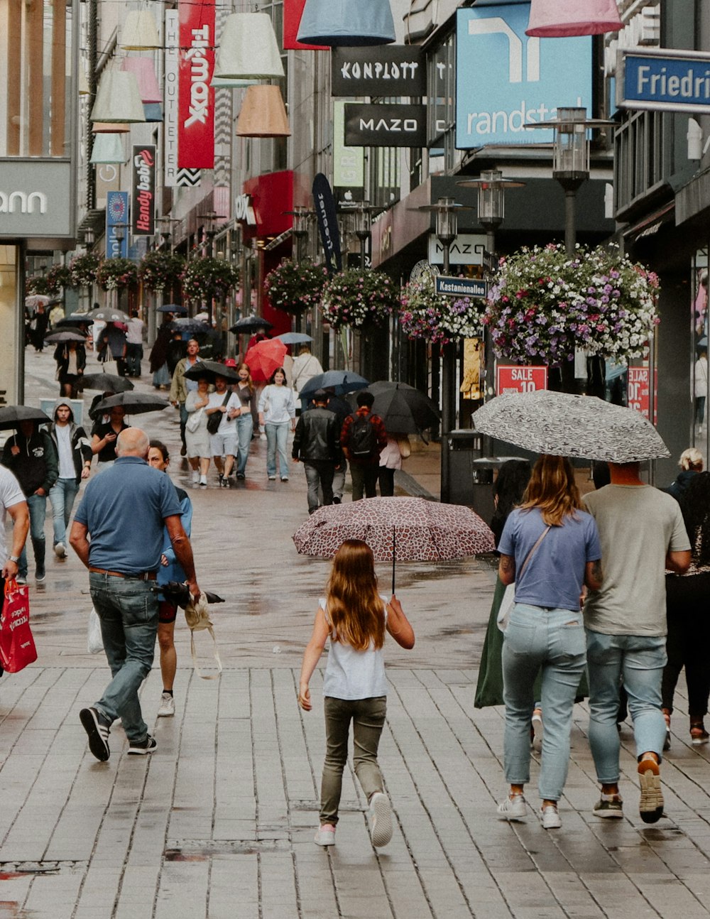 a group of people walking down a street holding umbrellas