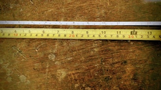 Professional measuring tape and notes on a wooden table during home consultation.