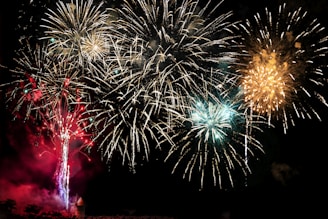 Explosive fireworks display lighting up the night with metallic gold and neon green colors.