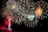 A vibrant daytime fireworks display lighting up a clear blue sky over a wedding venue.