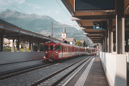 a red and white train pulling into a train station