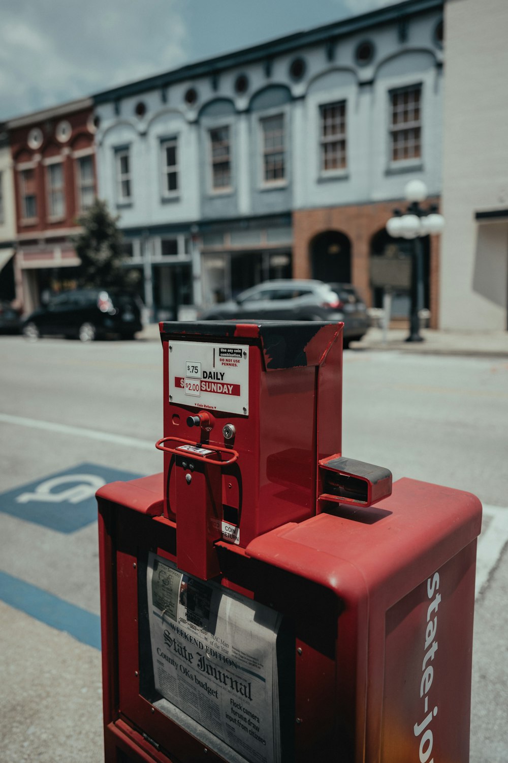 a red box sitting on the side of a road