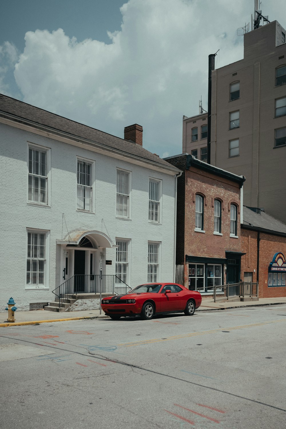 하얀 건물 앞에 주차된 빨간 차