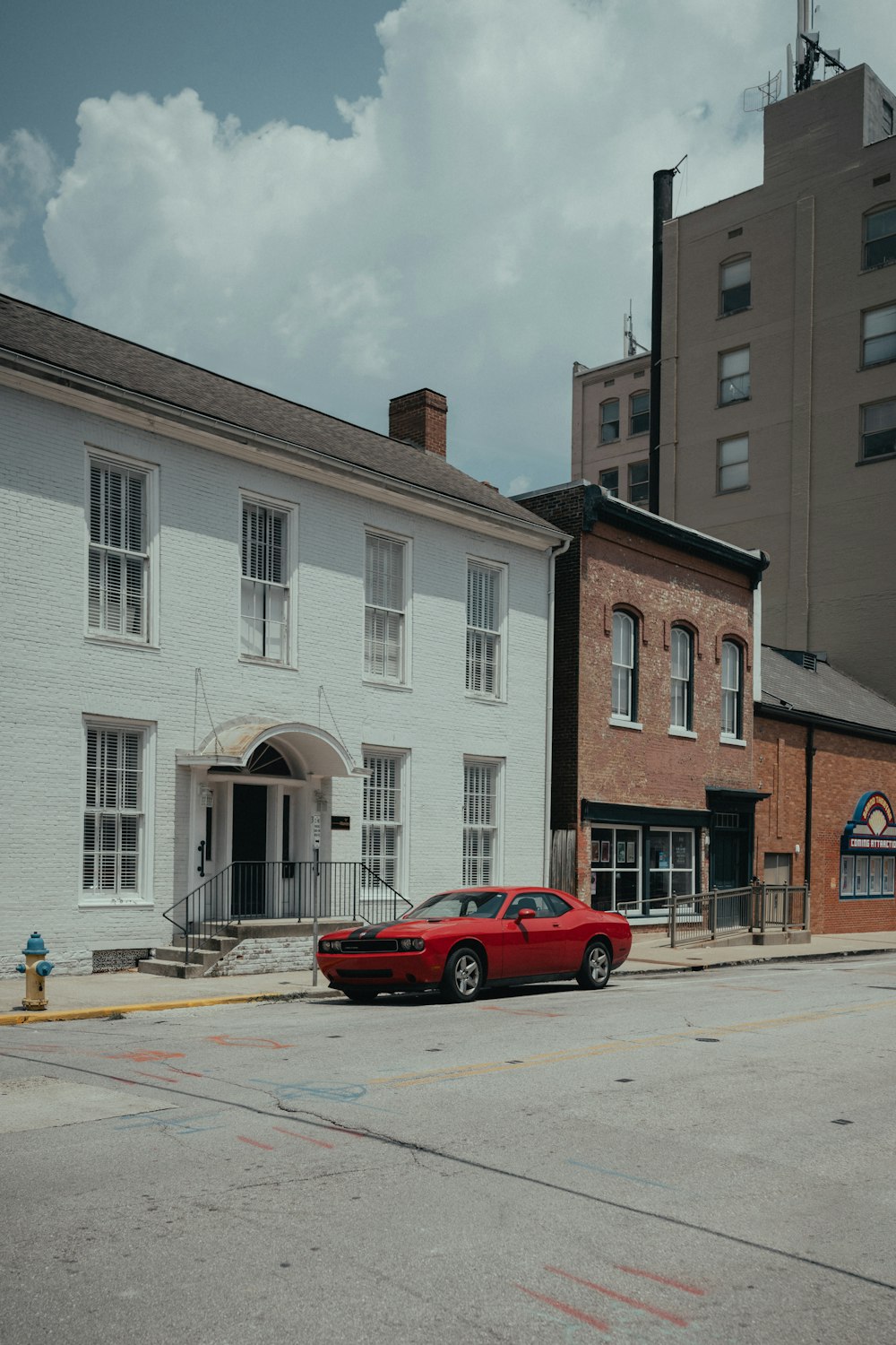 a red car parked in front of a white building