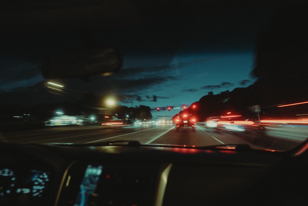 un coche conduciendo por una calle por la noche