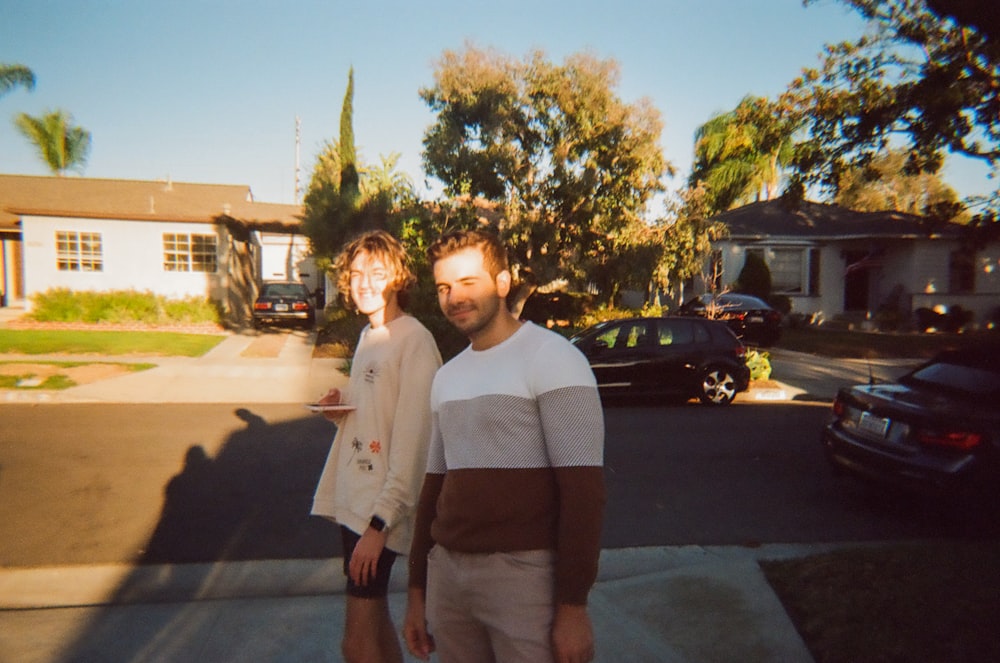 a man and a woman standing in front of a house