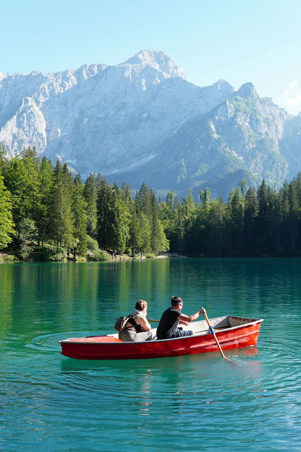 two people in a red boat on a lake