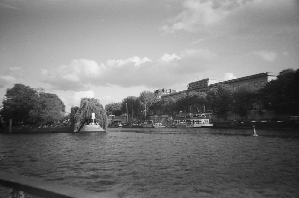 a boat traveling down a river next to a tall building