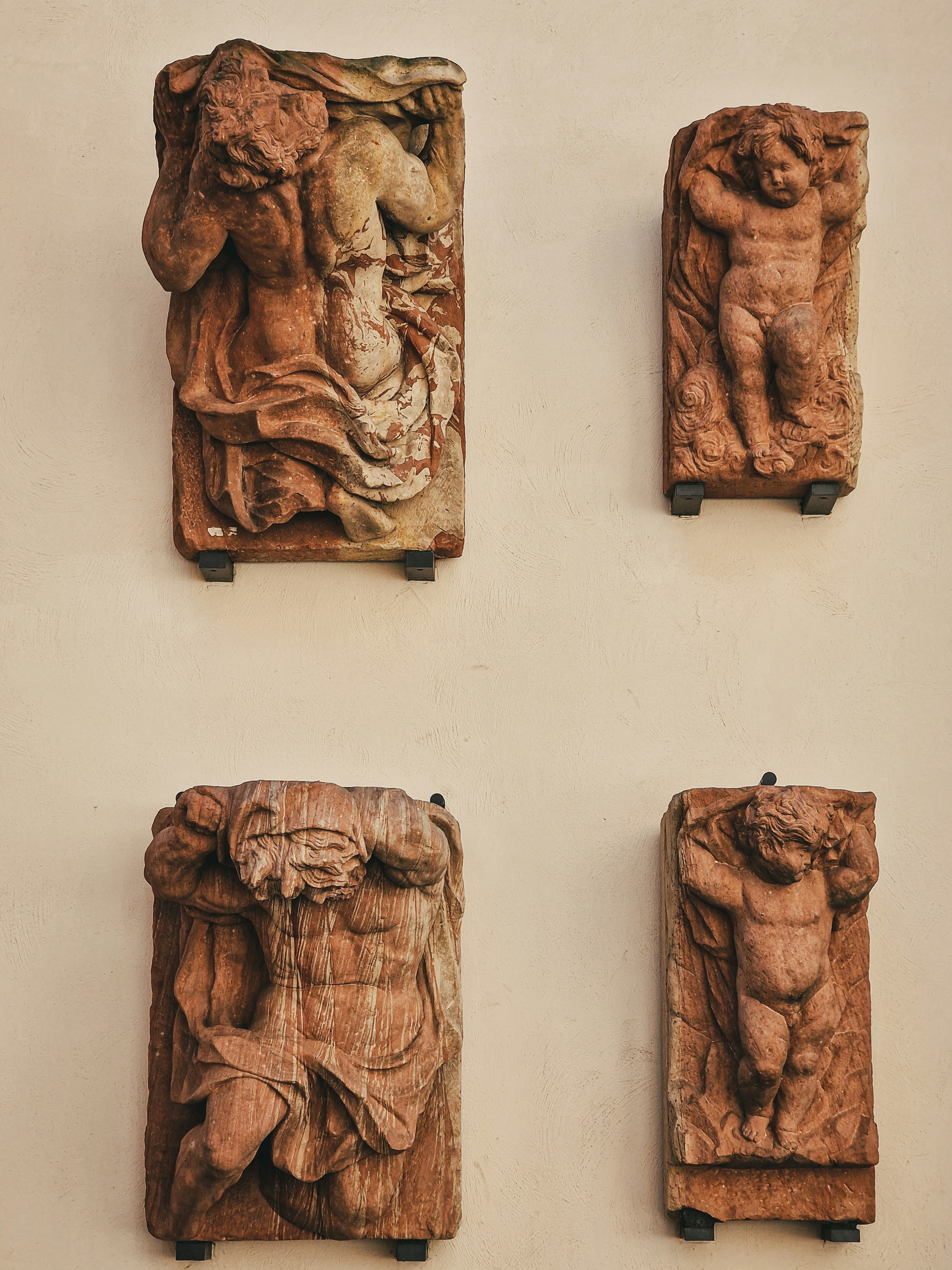 A group of four carved wooden sculptures on a wall photo – Free Woman ...