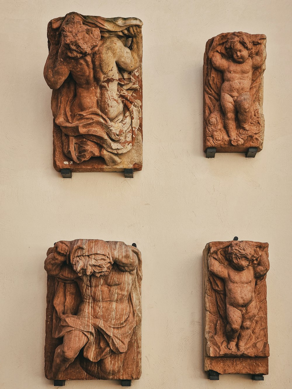 a group of four carved wooden sculptures on a wall