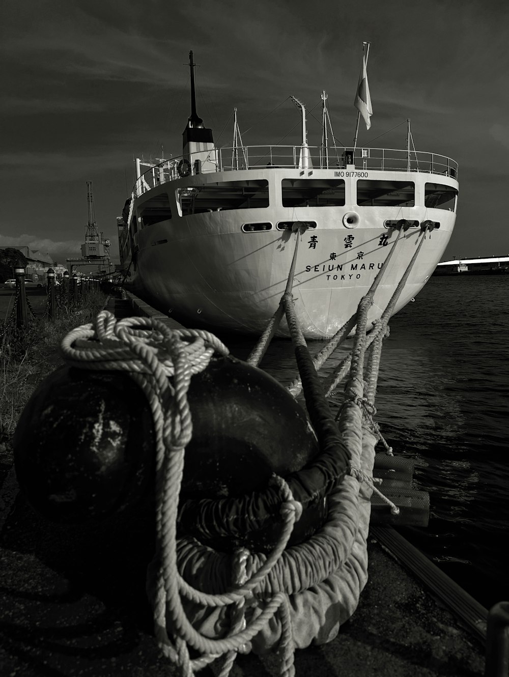 a boat tied up to a dock next to a body of water