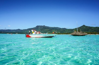 Tourists enjoying a boat excursion on calm turquoise waters under a bright sky.
